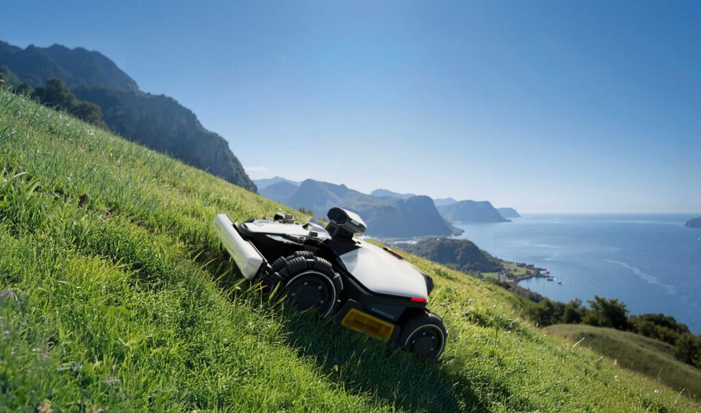 Robot tondeuse Mammotion LUBA 3 AWD en travers d'une pente herbeuse escarpée